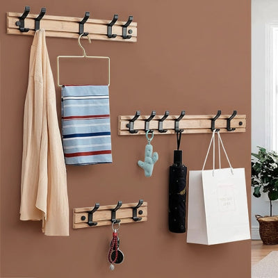 trois porte manteau trois cinq six crochets noirs un detail mur blanc