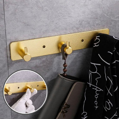 porte manteau mural dore trois crochets veste noire un detail
